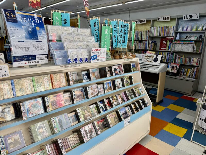 セントラル楽器に並ぶ奄美島唄のCDと音楽資料