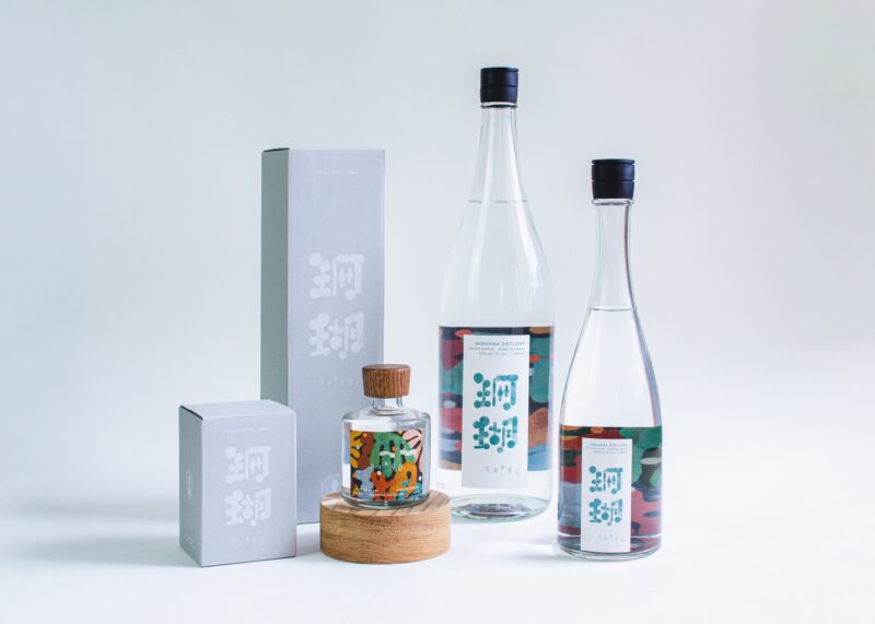 奄美大島の海を背景にした西平酒造の黒糖焼酎 SANGO（サンゴ）